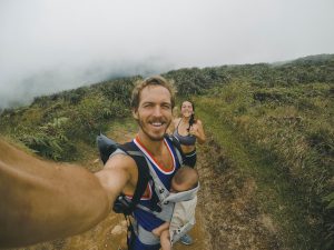 randonnée papa avec bébé dans porte bébé maman en arrière plan